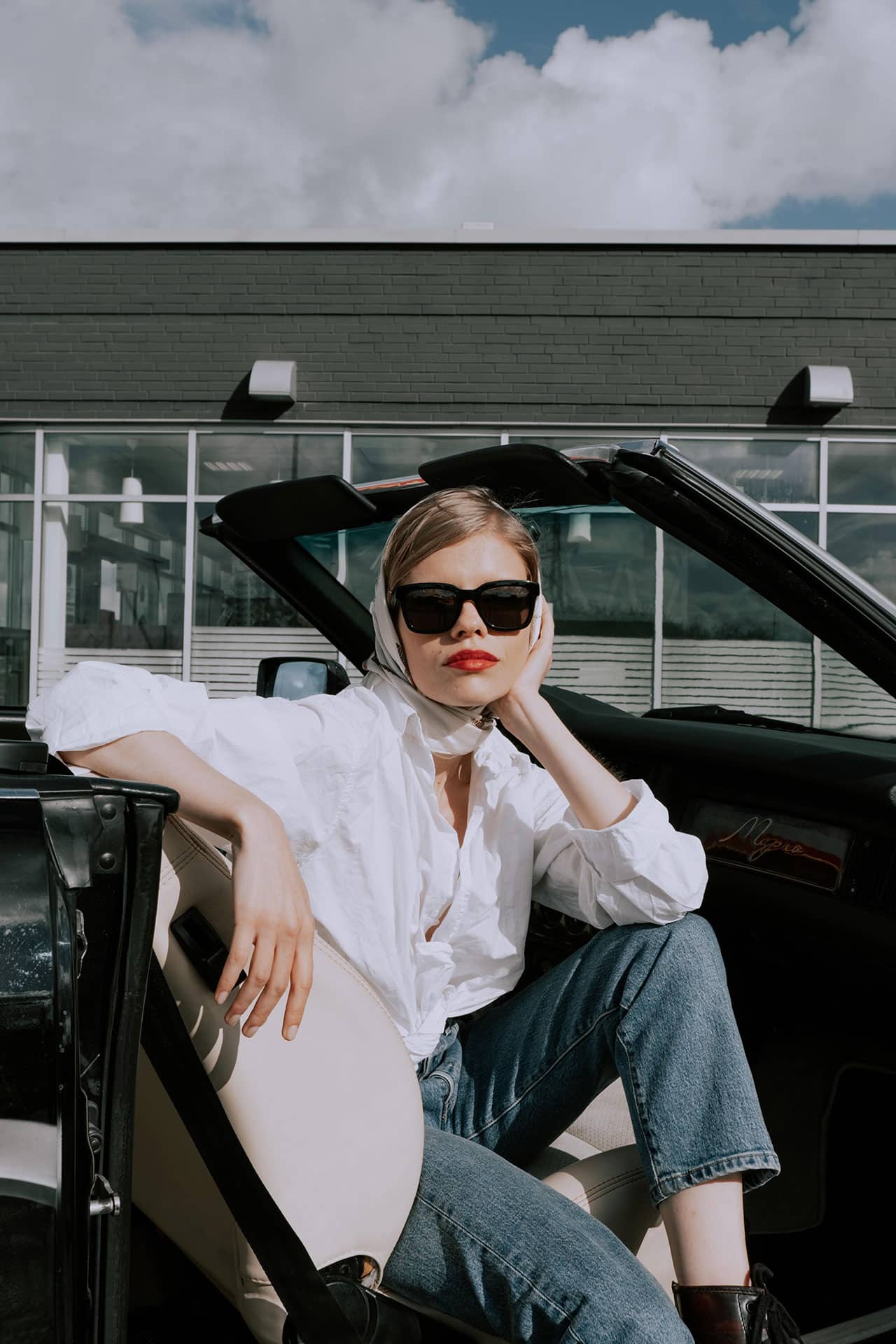 Woman in white shirt sitting in a convertible